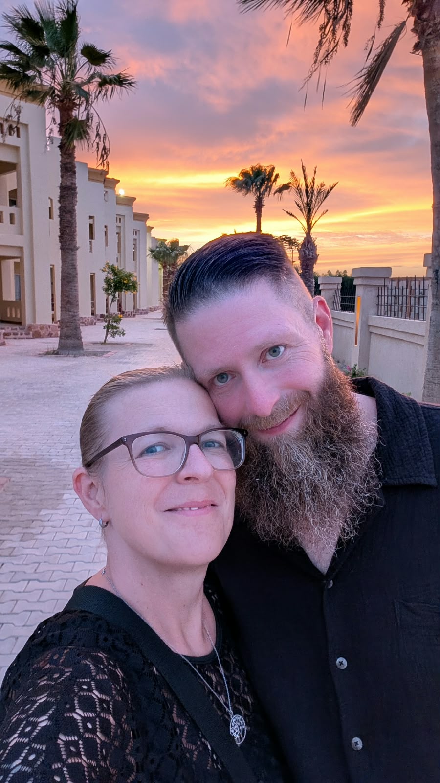 Sanni und Thomas vor einem farbenreichen Sonnenuntergang