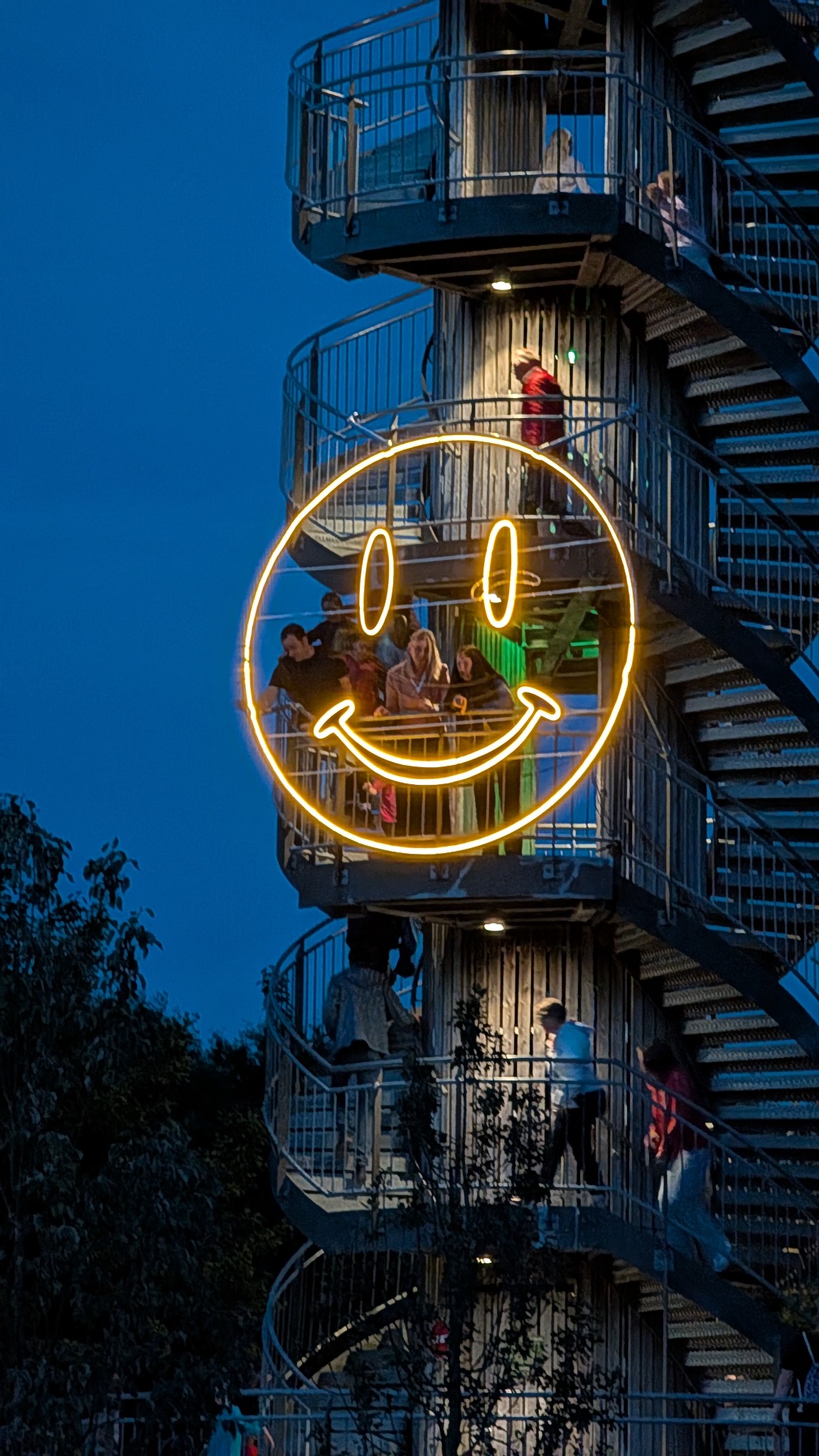 Leuchtender Smiley vor einem Aussichtsturm